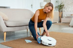full-shot-woman-with-robotic-vacuum-cleaner-home